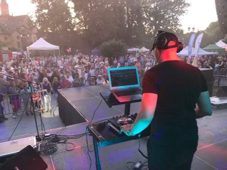 DJ Foku$ prowadzący zabawę na parkiecie podczas wesela z gośćmi tańczącymi przy efektach świetlnych.